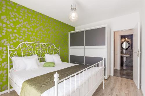 ein Schlafzimmer mit einem weißen Bett und einer grünen Wand in der Unterkunft Top Floor View Penthouse in Cluj-Napoca