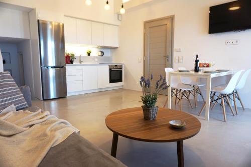 una cucina e un soggiorno con tavolo e frigorifero di Sunset Villa II a Nea Cryssi Akti