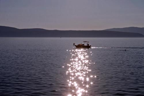 a boat in the middle of a body of water at Apartments Matic in Njivice