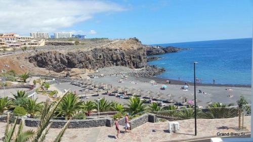 a beach with a bunch of umbrellas and the ocean at El Ancla - El Mar y La Playa in Callao Salvaje