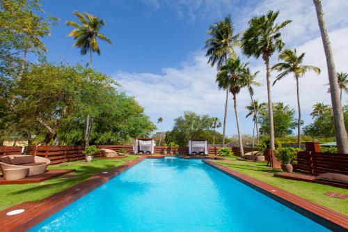 a swimming pool with palm trees in the background at Villa Montaña Beach Resort in Isabela