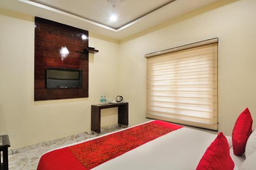 a bedroom with a large bed and a tv at The Grand Uddhav in New Delhi