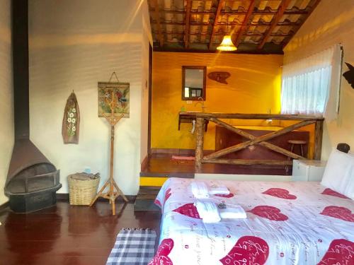 a bedroom with a bed and a fireplace at Pousada Recanto da Siriema in Monte Alegre do Sul