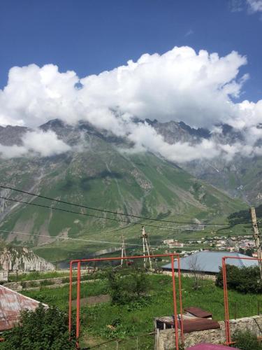 una vista de una montaña con nubes en el cielo en Home of Bella & Tamo, en Kazbegi