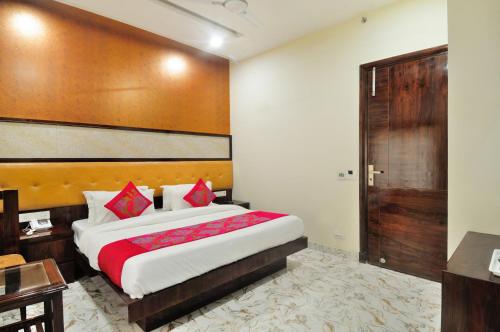 a bedroom with a large bed and a wooden headboard at The Grand Uddhav in New Delhi