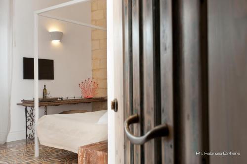 a door to a bedroom with a bed and a desk at Palazzo Dei Dondoli in Lecce