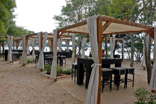 a row of tables and chairs under a pavilion at Apartments Matic in Njivice