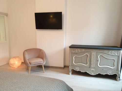 ein Schlafzimmer mit einer Kommode, einem Stuhl und einem TV in der Unterkunft Le Clos Marceau in Bédoin