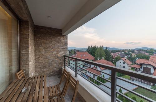 a balcony with a wooden bench and a view at Vip Casa Club Zlatibor in Zlatibor