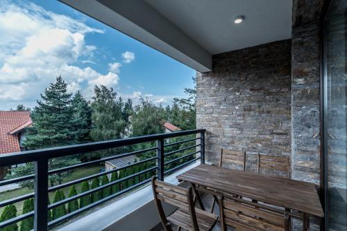 a balcony with a wooden table and two chairs at Vip Casa Club Zlatibor in Zlatibor