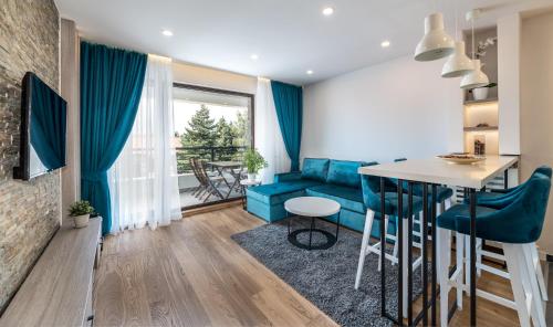 a living room with a blue couch and a table at Vip Casa Club Zlatibor in Zlatibor