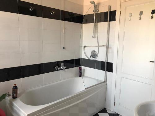 La salle de bains est pourvue d'une baignoire blanche et de carrelage noir et blanc. dans l'établissement Sparkling Art Como, à Côme