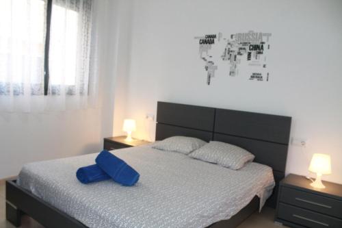 um quarto com uma cama com uma almofada azul em Piso Regina em Lloret de Mar