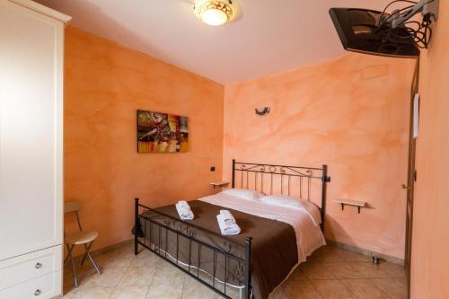 a bedroom with a bed in a room with orange walls at Camere La Basilica in Assisi