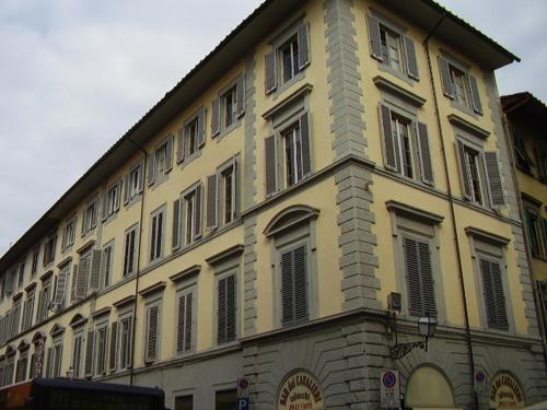 ein großes gelbes Gebäude mit vielen Fenstern in der Unterkunft 27 Aprile in Florenz