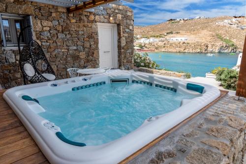 a hot tub in a patio with a view of the water at Etesians Suites & Villas in Super Paradise Beach