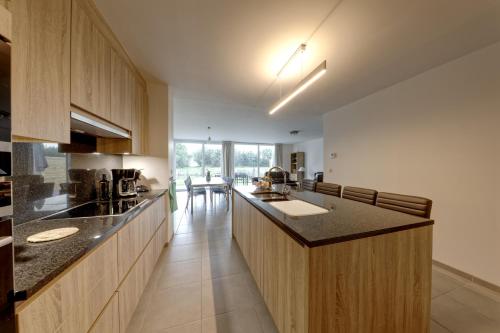 a kitchen with a large island in the middle at Aan de duinbossen in De Haan