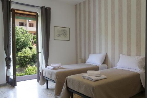 a room with two beds and a window with a balcony at Pepè Apartment -Lago di Bracciano in Trevignano Romano