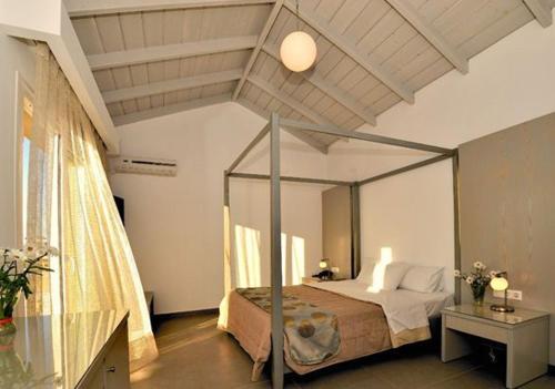 ein Schlafzimmer mit einem Himmelbett in einem Zimmer in der Unterkunft Apolis Beachscape Hotel in Amoopi
