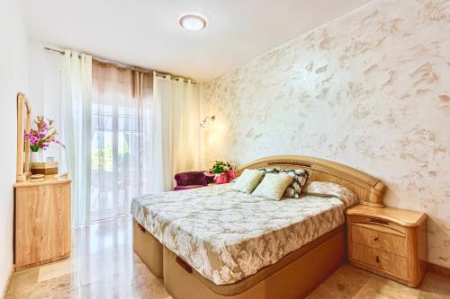 1 dormitorio con cama y ventana grande en Apartamento en Playa la Arena, en Puerto de Santiago