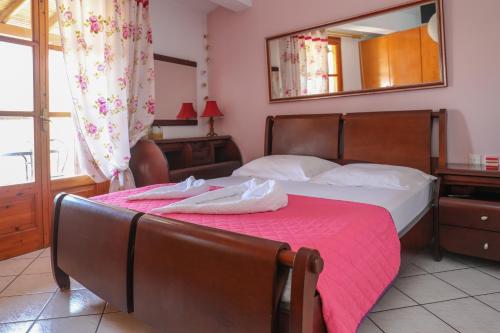 a bedroom with a bed with a pink blanket at Vaya Zorba Studios in Skiathos Town