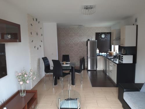 a kitchen and living room with a table and chairs at Apartament Piotr in Łeba