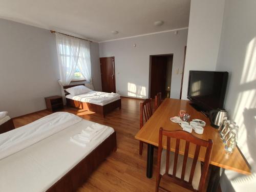Zimmer mit 2 Betten, einem Tisch und einem Esszimmer in der Unterkunft Missterium Zakliczyn in Zakliczyn