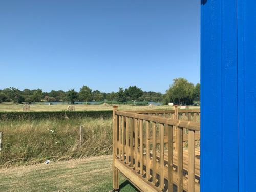 a wooden fence with a field in the background at Camping du Lac de Saujon in Saujon