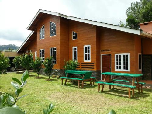 a house with green picnic tables in front of it at Villa Fresh Line in Bongkar 2