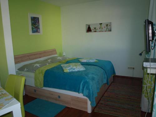 プレッセッガー・ゼーにあるRuhe am Seeのベッドルーム1室(青い毛布付きのベッド1台付)