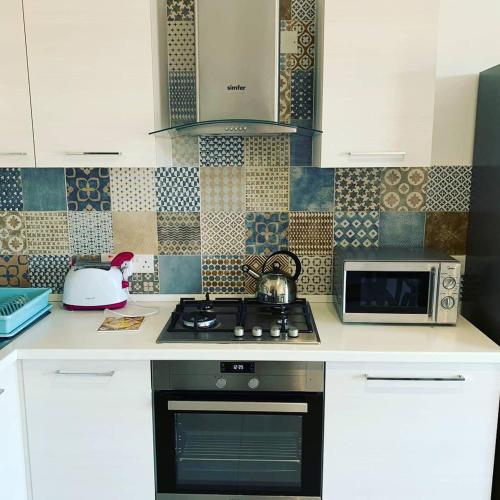 a kitchen with a stove and a microwave at Island Break Residence in Marsalforn