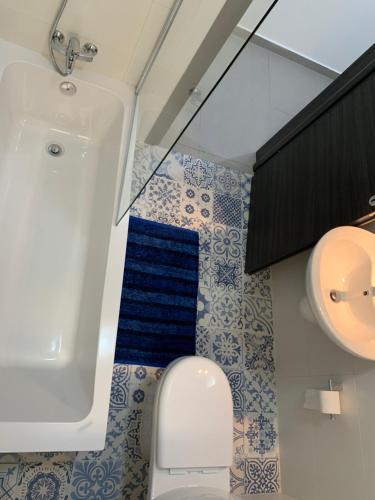 a bathroom with a tub and a toilet and a sink at Island Break Residence in Marsalforn