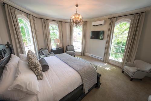a bedroom with a large bed and a chandelier at Serenity Inn Newport in Newport