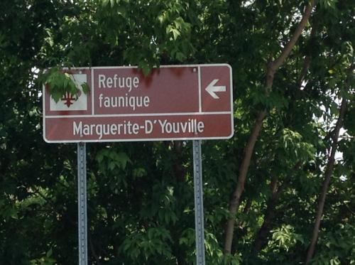 a brown street sign in front of some trees at Manoir d'Youville in Châteauguay Heights