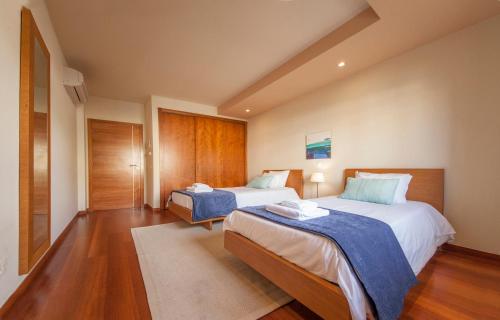 a hotel room with two beds and wooden floors at B27 - LuzBay 2 Bed Apartment in Luz