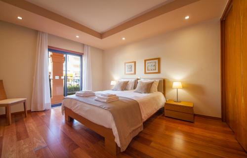 um quarto com uma cama grande e uma janela em B27 - LuzBay 2 Bed Apartment na Praia da Luz
