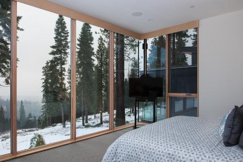 Schlafzimmer mit einem Bett und großen Glasfenstern in der Unterkunft Luxury 4BD True Ski-In/Ski-Out Mid-Mountain Residence - Stellar Northstar in Truckee