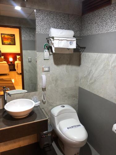 a bathroom with a white toilet and a sink at Hotel Europa in Iquitos