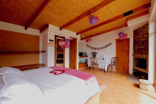 a bedroom with a large bed and a dining room at Titué Refugio , Cabañas in La Calera