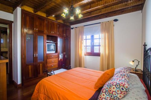 A1 Casas Y Villas juani y juan lanzarote (tomaren) Free WiFi في سان بارتولومي: غرفة نوم بسرير برتقالي ونافذة