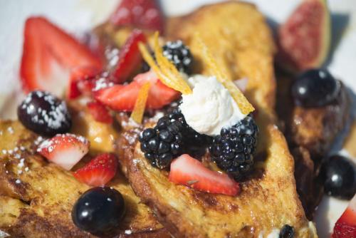 a plate of french toast with fruit and whipped cream at Serenity Inn Newport in Newport