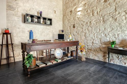 a room with a table and a stone wall at Giardini Acantus in Rosolini