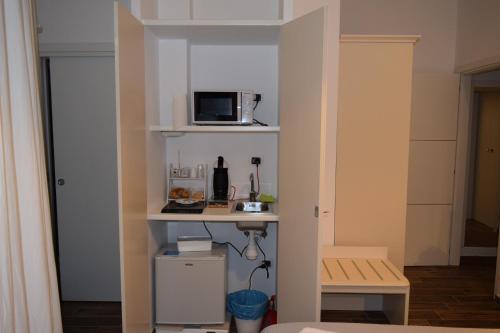 DomuS al Corso B&B في كانوسا دي بوليا: مطبخ صغير مع ميكروويف على رف