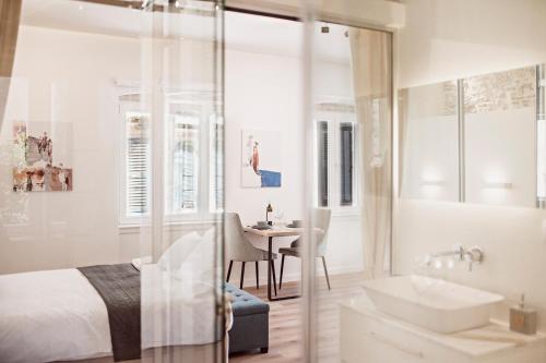 una camera con letto, lavandino e tavolo di S&G Corfu Old Town Apartments - The Volto Suite a Città di Corfù