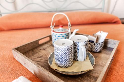 a tray with three cups on top of a bed at Giardini Acantus in Rosolini