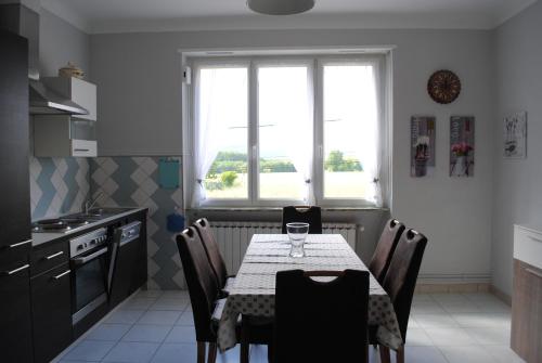 a kitchen with a table with chairs and a window at AU LOGIS DU SIMSERHOF in Hottviller