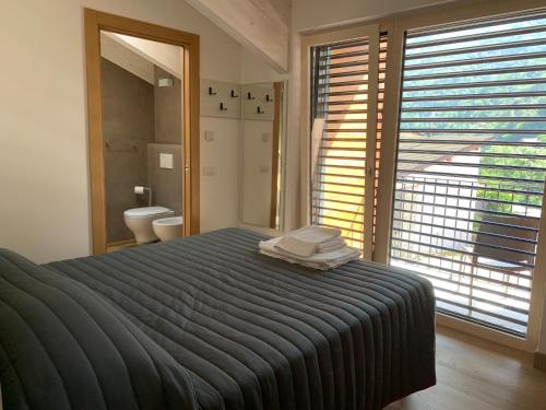 a bedroom with a large bed and a bathroom at Italo-Svizzero in Chiavenna