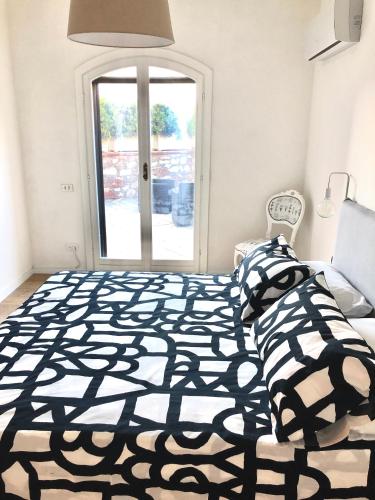 a bedroom with a black and white bed and a window at Casa Mari in Principina Terra