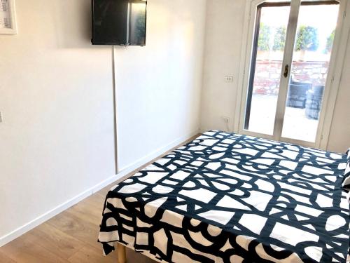 a bedroom with a black and white bed and a window at Casa Mari in Principina Terra