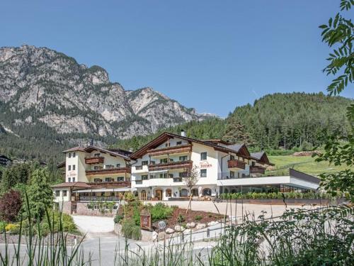 a large building in front of a mountain at Hotel Dosses in Tires